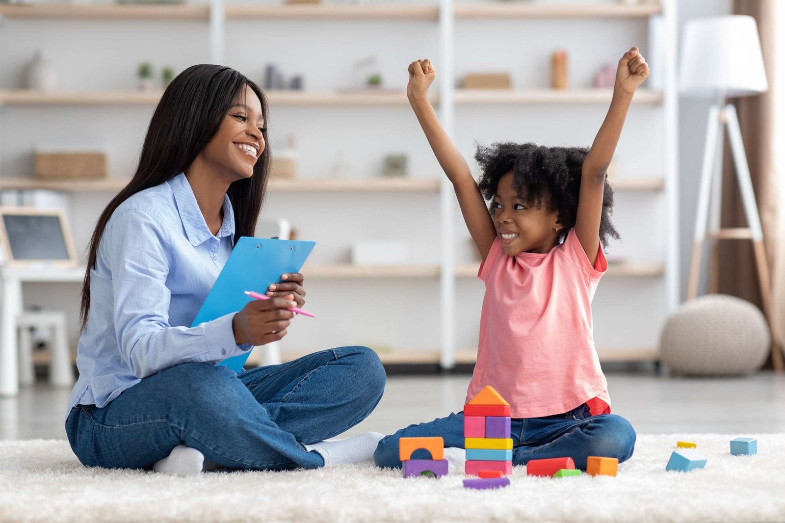 emotional-little-girl-raising-hands-up-having-session-with-psychologist